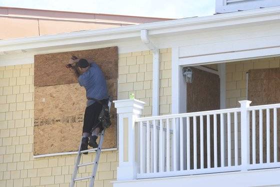 3일 미국 노스캐롤라이나주 오크섬 주민들이 강한 바람을 막기 위해 창문과 현관을 봉쇄하고 있다.[AP=연합뉴스]