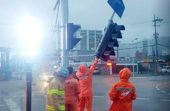 7일 오전 6시께 해남군 해남읍 한 주유소 인근 교차로에서 신호등 1개가 강풍에 파손돼 소방당국이 안전조치를 하고 있다.[사진 해남소방서]
