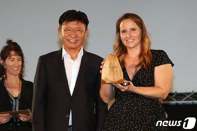 10일 오후 울산시 울주군 영남알프스 복합웰컴센터에서 열린 '제4회 울주세계산악영화제(UMFF)' 폐막식에서 국제경쟁 대상에 선정된 '강 그리고 장벽'의 감독 벤 마스터스를 대신해 프로듀서 힐러리 피어스 대리 수상자(오른쪽)가 영화제 이사장인 이선호 울주군수로부터 상패를 수여받은 후 기념사진을 찍고 있다. 2019.9.10/뉴스1 © News1 윤일지 기자