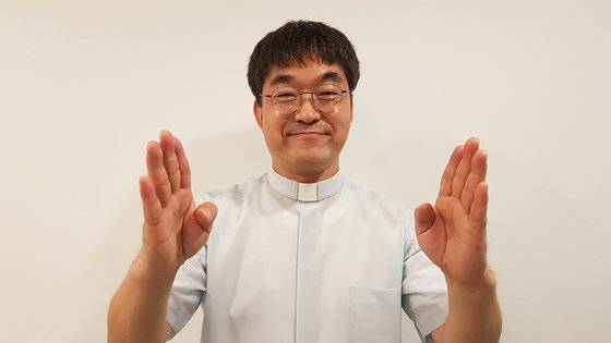 박민서 신부가 수어로 ‘서로 닫힌 마음을 열어보세요’라고 말하고 있다.