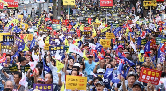 지난 9일 서울 세종문화회관 옆 소공원에서 열린 '분양가상한제 소급적용 저지 재개발·재건축 조합원 총궐기대회'에서 참가 조합원들이 구호를 외치고 있다.<연합뉴스>