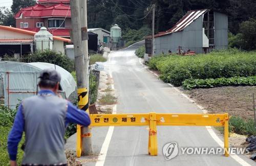 돼지열병 의심 신고된 인천 강화 양돈농장 (인천=연합뉴스) 윤태현 기자 = 인천 강화군 한 양돈농장에서 국내 다섯 번째로 아프리카돼지열병(ASF)이 확진돼 방역당국에 비상이 걸린 지난 25일 오전 ASF 의심 신고가 접수된 인천시 강화군 불은면 한 양돈농장 입구에 외부인 출입을 막는 바리케이드가 설치돼 있다. tomatoyoon@yna.co.kr