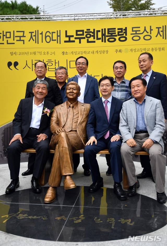 【부산=뉴시스】 하경민 기자 = 7일 부산 부산진구 개성고등학교(옛 부산상고) 교정에서 열린 노무현 전 대통령 동상 제막식에 참석한 김경수 경남도지사 등이 기념촬영을 하고 있다.  개성고 총동창회가 모금 운동을 통해 모은 기금 총 3억원을 투입해 제작한 동상은 청동 재질로, 정장 차림의 노 전 대통령이 벤치에 팔을 기대고 앉은 형상이다. 특히 누구나 동상 옆에 앉아서 기념사진을 찍을 수 있도록 조성됐다. 2019.10.07. yulnetphoto@newsis.com