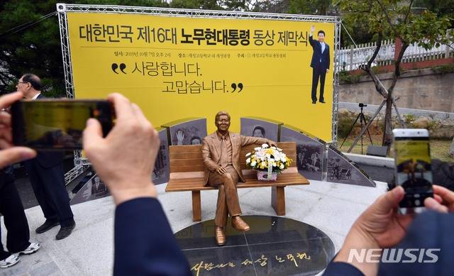 【부산=뉴시스】 하경민 기자 = 7일 부산 부산진구 개성고등학교(옛 부산상고) 교정에서 열린 노무현 전 대통령 동상 제막식 참가자들이 기념촬영을 하고 있다.   개성고 총동창회가 모금 운동을 통해 모은 기금 총 3억원을 투입해 제작한 동상은 청동 재질로, 정장 차림의 노 전 대통령이 벤치에 팔을 기대고 앉은 형상이다. 특히 누구나 동상 옆에 앉아서 기념사진을 찍을 수 있도록 조성됐다. 2019.10.07. yulnetphoto@newsis.com