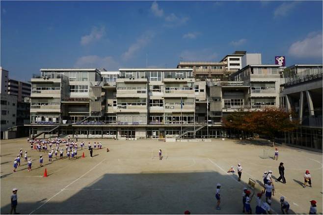 후쿠오카에 위치한 하카타 초등학교 전경. 운동장에서 아이들이 신나게 놀고 있다