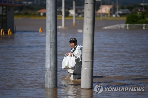 식료품 들고 침수지역 지나는 日 봉사자 (시바타 AFP=연합뉴스) 태풍 '하기비스'가 강타한 일본 미야기현 시바타에서 13일 한 남성이 침수로 고립된 주민들에게 제공할 식료품을 들고 홍수 지역을 지나고 있다. bulls@yna.co.kr