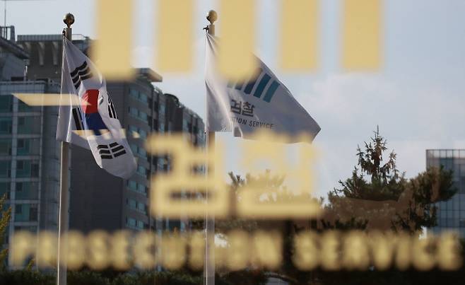 서울 서초동 중앙지검 앞 태극기와 검찰기가 바람에 나부끼는 모습이 청사 유리창에 반사되고 있다. 연합뉴스