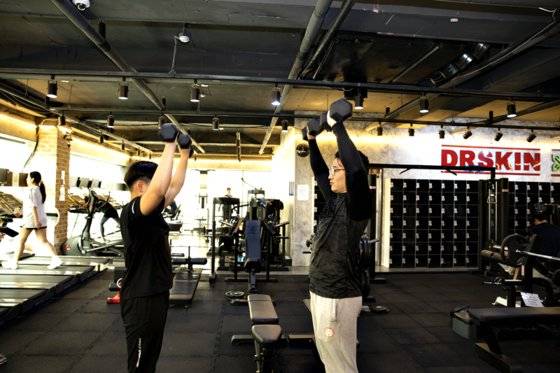 구자원(오른쪽) 주장이 승민이에게 팔을 다치지 않고 아령을 드는 법을 설명하고 있다.