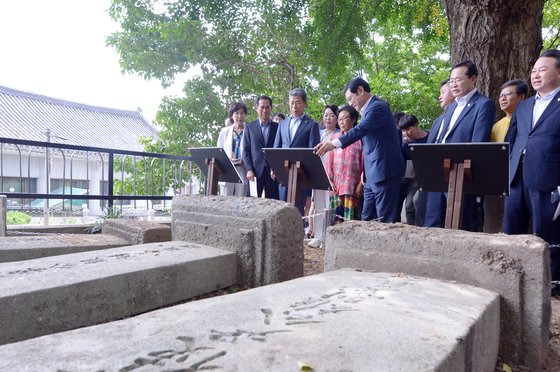 지난 8월 광주 남구 광주공원에서 열린 '친일잔재 청산 단죄문 제막식' 도중 이용섭 광주시장 등 참석자들이 일제 국권침탈 부역자로 분류되는 윤웅렬·이근호·홍난유의 선정비 앞에 세워진 단죄문을 바라보고 있다. 이들의 비석은 광주공원 사적비석군의 다른 비석들과 달리 땅에 눕혀져 있다. [뉴스1]