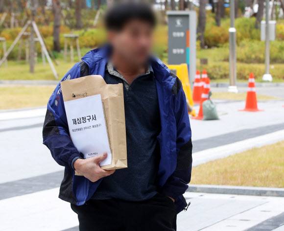 화성연쇄살인 8차 사건의 범인으로 검거돼 20년간 ‘억울한 옥살이’를 했다고 주장해 온 윤모(52) 씨가 재심청구서를 들고 13일 오전 경기도 수원시 영통구 수원지방법원으로 들어가고 있다. 2019.11.13 연합뉴스