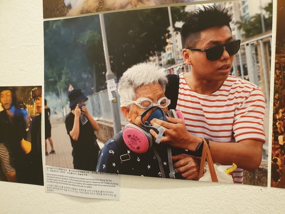 8월 홍콩 시위 현장에 최루탄이 터지자 한 청년이 방독면을 벗어 노인에게 씌워준 모습을 담은 사진도 이 갤러리에 전시됐다. 이병준 기자