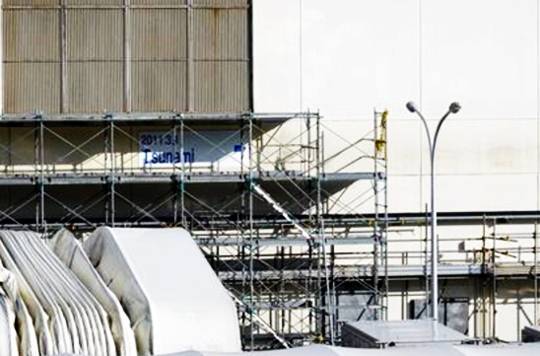 제1원전 부속건물 외관의 모습. 건물 가운데 부분에 ‘2011.3.11 tsunami’라는 글자가 적혀 있고 주변으로 검은 띠 모양이 보이는데 쓰나미가 몰려왔을 때 물이 찬 흔적이다. 연합뉴스