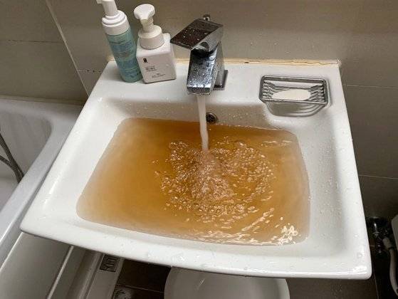 아파트 세면대 수도에서 붉은빛을 띤 수돗물이 나오고 있다. [연합뉴스]