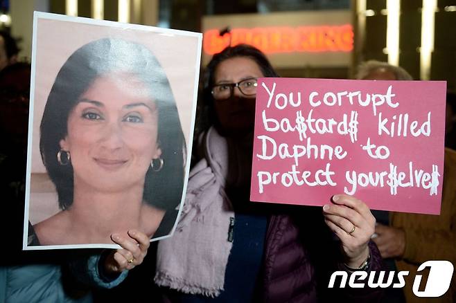 몰타 시민들이 피살된 갈리지아 기자의 사진을 들고 반정시위를 벌이고 잇다.  © AFP=뉴스1