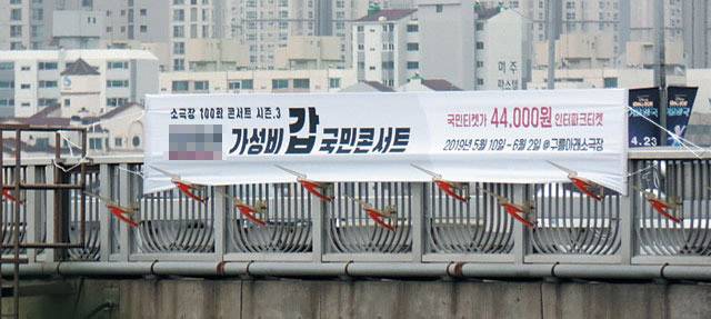 한남대교에 걸렸던 현수막 광고. 아래로 부리가 뾰족한 새 모양 조형물이 보인다. 현수막을 못 걸게 서울시설공단에서 조형물을 설치했지만 절묘하게 이를 피해 현수막을 걸었다.