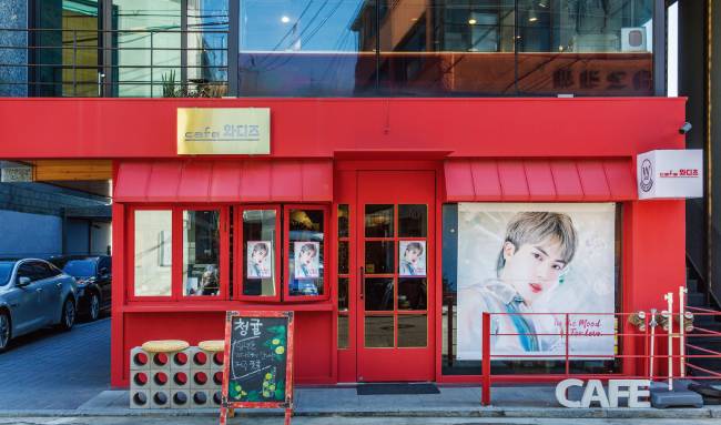 강렬한 레드 컬러의 서울 마포구 ‘카페 와디즈’ 외관에는 방탄소년단 멤버 진의 대형 얼굴 현수막이 걸려 있다. [김도균]