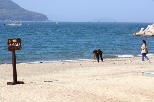 탐방객이 모래 해변에 어떤 글귀를 쓰고 있다.[사진/전수영 기자]