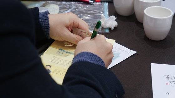 행사의 마지막 시간, 마음에 드는 이성의 이름을 매칭표에 적고 있다. 다른사람이 볼까 가리면서 적는 모습. 최연수기자
