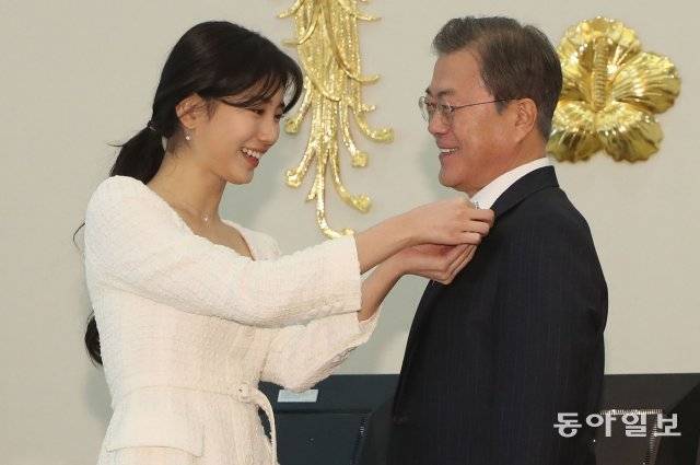 사랑의열매 홍보대사 방송인 수지 씨가 문재인 대통령에게 사랑의열매 배지를 옷깃에 달아주고 있다.