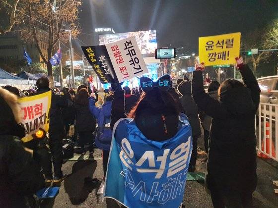 서초 달빛 집회 참가자들이 일어선 채 검찰을 비판하는 구호를 외치고 있다. 편광현 기자