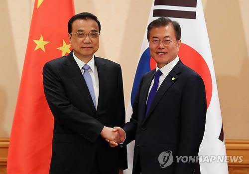 문재인 대통령과 리커창 중국 국무원 총리가 2018년 5월 9일 오후 일본 도쿄 데이코쿠(帝國) 호텔에서 열린 회담에서 악수하고 있다. [연합뉴스 자료사진]