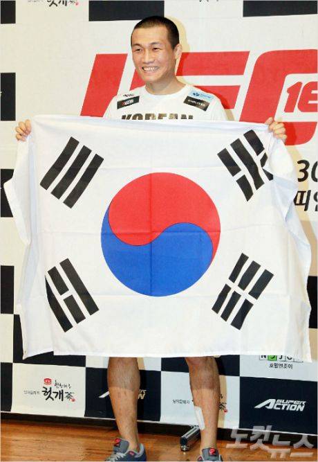 정찬성이 조제 알도와 UFC 타이틀전을 갖기 전 기자회견장에서 태극기를 들고 웃고 있다. 윤창원 기자/자료사진