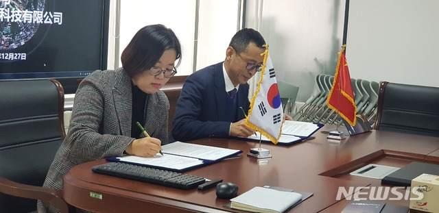 [안동=뉴시스] 김진호 기자 = 박성아(왼쪽) 문보트 대표와 신배군 DCT 북방지역 대표가 문보트 중국진출 사업 추진을 위한 업무협약(MOU)을 체결하고 있다. (사진=경상북도콘텐츠진흥원 제공) 2019.12.31 photo@newsis.com