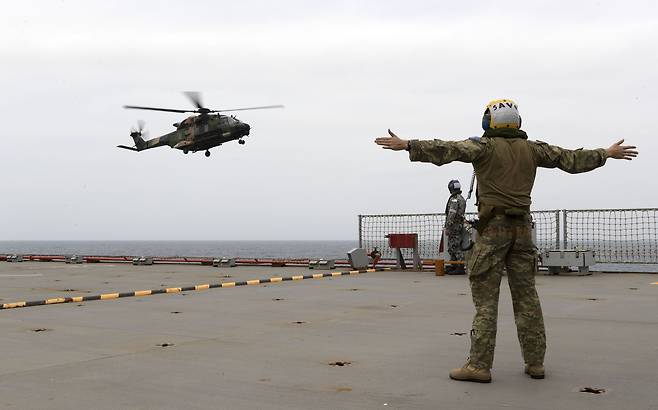 1일(현지시간) 뉴사우스웨일스 해안스웨일스 해안으로 출동을 준비중인 군함정에 헬기가 착륙하고 있다. [AFP=연합뉴스]