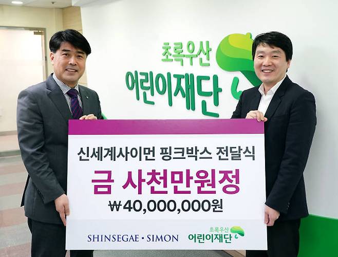 정원철 신세계사이먼 CSR팀장(오른쪽)이 이형진 초록우산어린이재단 서울북부지역본부장에게 4000만원 상당의 핑크박스를 전달하고 있다.