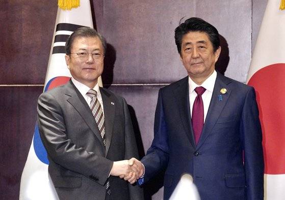 제7차 한·중·일 정상회의 참석을 위해 중국 쓰촨성 청두를 방문한 문재인 대통령(왼쪽)이 지난해 12월 24일 (현지시간) 아베 신조 일본 총리를 만나 악수하고 있다. [청와대사진기자단]