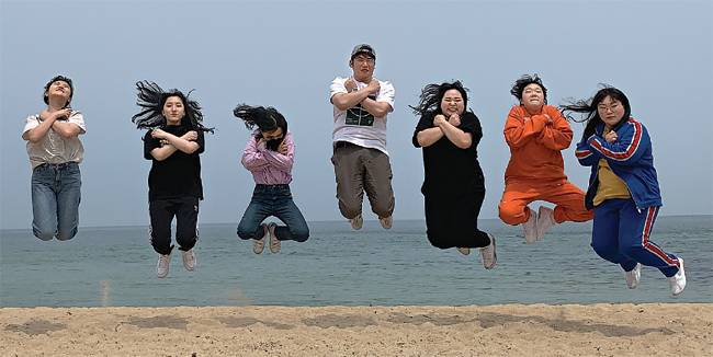 고도현(가운데) 홍천여고 교사와 학생들이 현장체험 학습으로 방문한 바닷가 해변에서 함께 점프하며 재미있는 포즈로 사진을 촬영하고 있다.