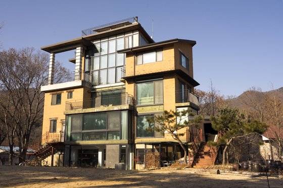 용인 ‘생각을담는집’. 1층은 북카페, 3~4층은 숙소로 사용한다. 큼지막한 창과 수많은 화초 덕에 온실처럼 아늑한 분위기다.