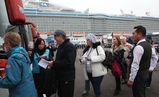 부산항 국제여객터미널에 입항한 크루즈선에 탑승했던 승객들이 하선한 뒤 버스를 타고 있다. [중앙포토]