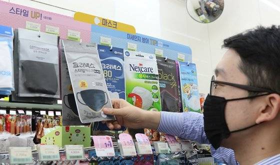 마스크를 착용한 한 고객이 편의점에서 마스크를 고르고 있다. [사진 BGF리테일]