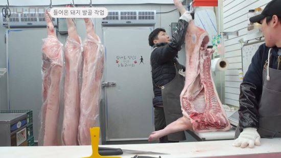 지난 1일 서울 방화동 방신시장의 한 정육점에 도축한 돼지고기 덩어리 4개가 내려지고 있다. 차인선 PD
