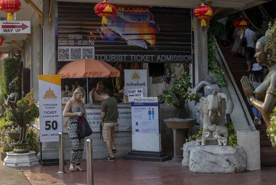 지난 3일 태국 방콕의 불교 사원 앞에서 서양인 관광객들이 입장권을 사고 있다. 방콕의 대표적 관광 명소인 이 사원에는 지난해 4000만명이 방문했으며, 이 가운데 1100만명이 중국인이었다. 그러나 올해 신종 코로나 확산으로 소수의 서양인들만 이 곳을 찾고 있다. [AP=연합뉴스]