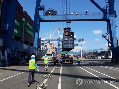 크레인 아래서 위험하게 컨테이너 고정장치 체결·제거작업 부산 북항의 한 부두의 노동자들이 크레인 바로 아래에서 컨테이너 고정장치인 콘을 체결하고 제거하는 작업을 하고 있다[촬영 이영희]