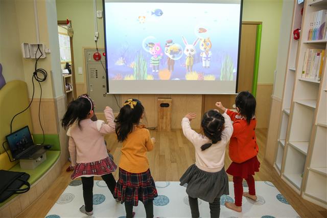 한 구립어린이집 원아들이 ‘스마트체육관’에서 영상 속 캐릭터와 하나가 돼 움직이며 활동하고 있다.성동구 제공