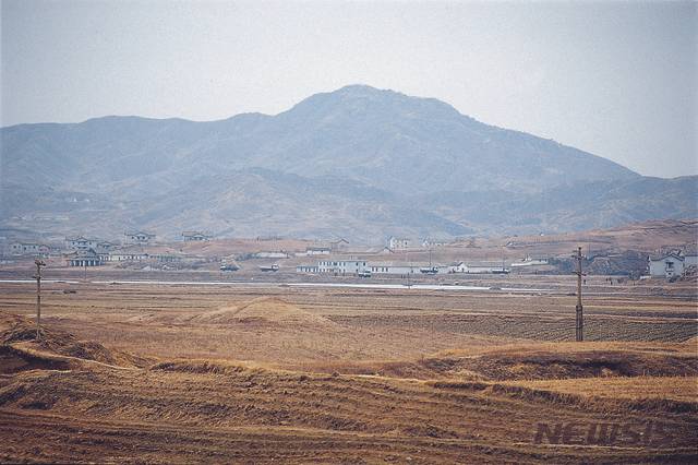 [서울=뉴시스] 평양에서 개성을 거쳐 판문까지 이어지는 고속도로에서 서쪽으로 진봉산의 북쪽 봉우리가 보인다. 2003년 2월 당시 개성공단 착공식을 앞두고 부지공사가 한창이어서 도로를 오가는 트럭들이 많이 보였다. (사진=평화경제연구소 제공) 2020.02.15. photo@newsis.com