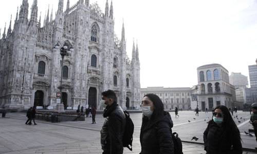 이탈리아 북부 밀라노에서 신종 코로나바이러스 감염증(코로나19) 우려로 마스크를 착용한 사람들이 고딕 대성당인 ''두오모'' 앞을 지나가고 있다. 밀라노=AP연합뉴스