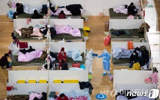 (우한 AFP=뉴스1) 우동명 기자 = 18일 (현지시간) 코로나 19의 발원지인 후베이성 우한의 체육관에 설치된  칸막이가 쳐진 임시병원에서 의료진들이 경증환자들을 점검하고 있다.  ⓒ AFP=뉴스1  <저작권자 ⓒ 뉴스1코리아, 무단전재 및 재배포 금지>