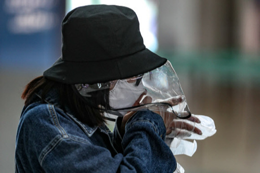 지난 26일 인천국제공항 제1터미널 출국장에서 중국인 관광객이 비닐 모자와 장갑을 착용하고 있다. 뉴스1