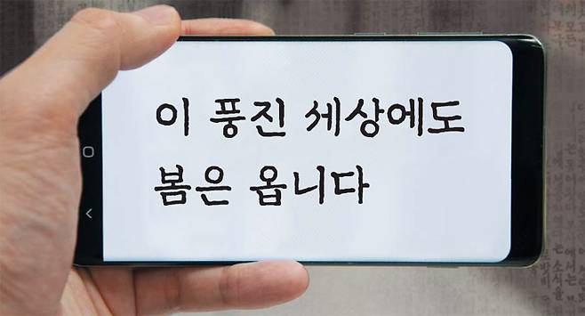 스마트폰에 '조선 100년체' 이미지를 띄운 모습. 살짝 울퉁불퉁한 획의 윤곽선에서 옛 신문의 인쇄 질감이 느껴진다. 두 획이 같은 방향을 가리키는 ‘세’의 ㅅ이나, 받침 ㄴ의 세로줄기가 비스듬하게 누운 모습이 특징이다. /채민기 기자