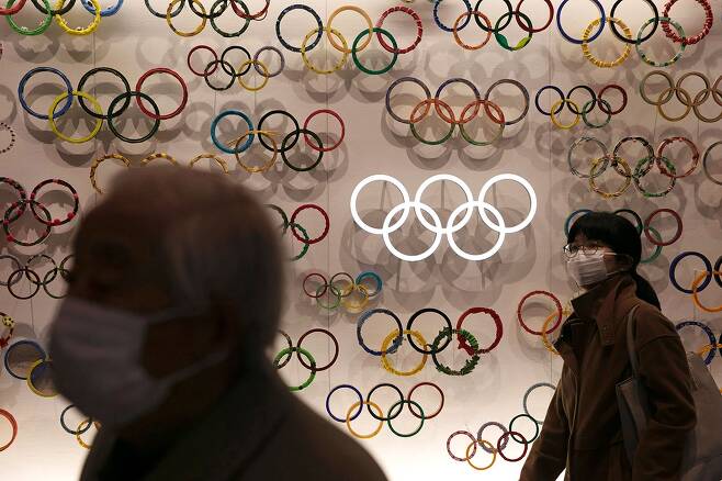 ⓒAFP PHOTO마스크를 낀 일본 시민들이 2월23일 도쿄의 올림픽 박물관을 지나고 있다.