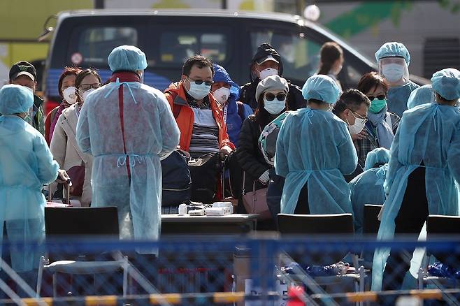 ⓒReuter요코하마항에 정박 중인 ‘다이아몬드 프린세스’호에서 내린 승객들이 2월21일 발열 검사를 받고 있다.