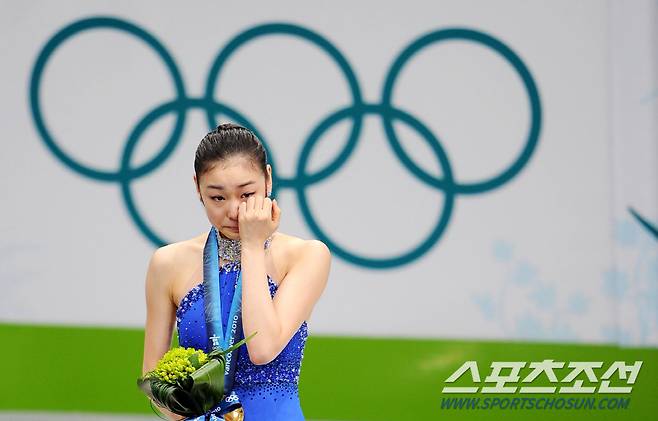 김연아가 시상대에 올라 눈물을 닦아내고 있다