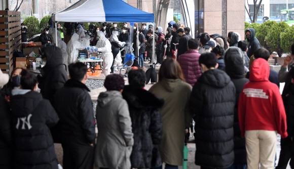 전염력 무서운데… 1m 거리도 확보 안된 선별진료소 - 서울 구로구 코리아빌딩 11층 보험회사 콜센터에서 서울 최대 규모의 코로나19 집단감염이 발생한 가운데 10일 오전 이 건물 1층 외부에 설치된 선별진료소에 검진을 받으려는 빌딩 입주자들이 몰려 북새통을 이루고 있다. 최근 질병관리본부의 코로나19 대응 매뉴얼 개정으로 ‘선별진료소에서 검진을 받을 땐 마스크를 쓰고, 서로 간에 1m 이상 떨어져야 한다’는 지침이 삭제되면서 큰 혼란이 벌어졌다는 지적이 나온다.오장환 기자 5zzang@seoul.co.kr