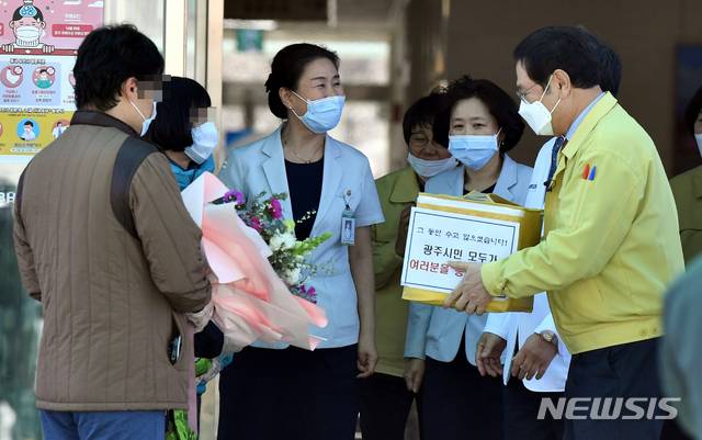 [광주=뉴시스] 류형근 기자 = 광주 감염병전문병원으로 지정된 남구 빛고을전남대학교병원에서 치료를 받은 코로나19 대구지역 확진자 가족이 11일 오후 퇴원한 가운데 이용섭 광주시장이 선물을 전달하고 있다. 2020.03.11. hgryu77@newsis.com