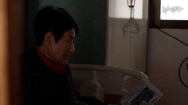 ▲ 1939년 아버지 이인석 관련 조선, 동아일보 기사를 보고 있는 딸