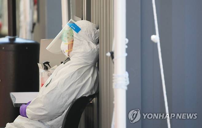 코로나19와의 전쟁 속 '짧은 휴식' (서울=연합뉴스) 2020년 3월 5일 오후 서울 송파구 잠실종합운동장 앞에 설치된 신종 코로나바이러스 감염증(코로나19) 드라이브 스루 선별진료소에서 의료진이 잠시 눈을 감고 앉아 있다. [연합뉴스 자료사진]